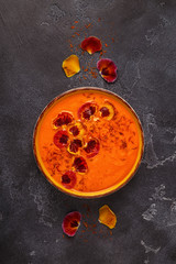 Smoothie or pumpkin / carrot soup with saffron and edible petals pansy flowers.