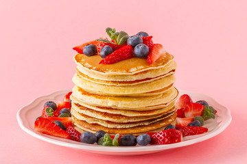 Pancakes with berries on a bright pastel background
