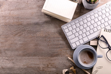 Workplace with stationery, keyboard and cup of coffee on table. Top view