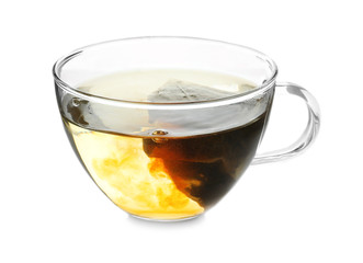 Brewing of hot tea in glass cup on white background