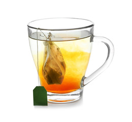 Brewing of hot tea in glass cup on white background