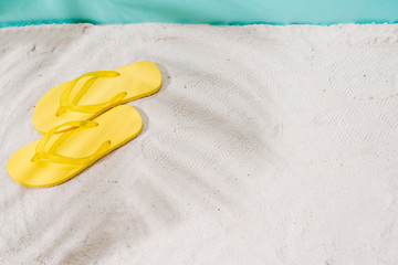 A Summer vacation background with a pair of sandals on beach