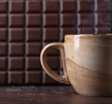 Cup of hot chocolate and a bar of dark bitter chocolate.
