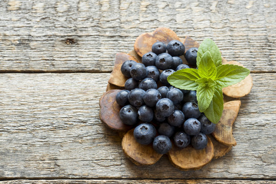 Blueberries on old wooden dishes, space for text