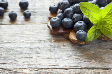 Blueberries on old wooden dishes, space for text