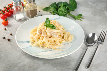 Plate of tasty pasta with chicken fillet on table