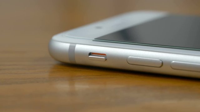 Left hand that puts the smartphone in silent mode