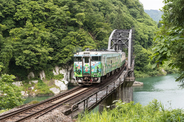 Fototapeta premium FUKUSHIMA, JAPONIA - 18 czerwca: Lokalny pociąg Tadami line i Tadami river w dniu 18 czerwca 2017 r. W Fukushima, Japonia. To pociągi na linii kolejowej firmy Tadami we wschodniej Japonii.