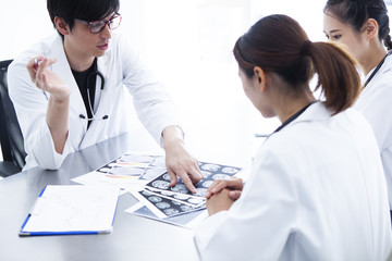 若手医師たちが資料を見ながら打ち合わせをしている