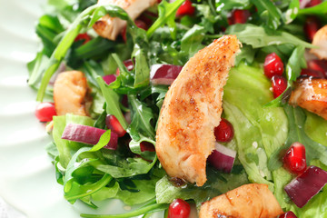 Tasty salad with meat and pomegranate seeds on plate