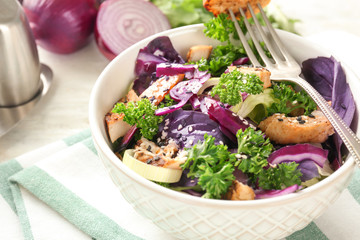Tasty salad with meat and parsley in bowl on table