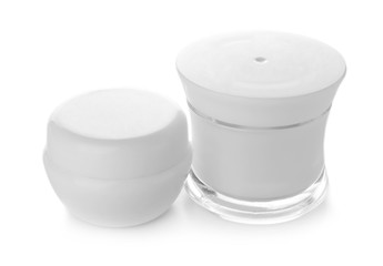 Jars of moisturizing cream on white background