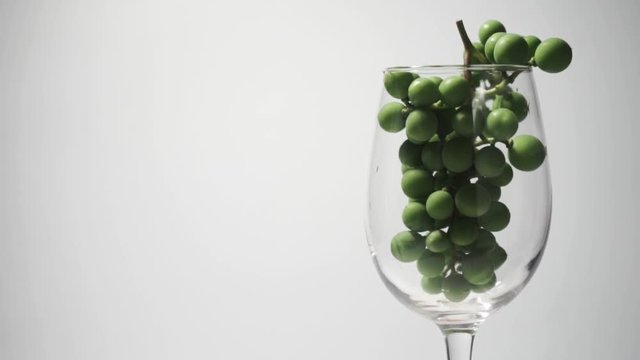  Glass full Green seedless grapes on a white table, rotation 360 degrees. White background.