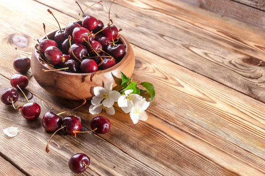 Fresh cherry in a wooden bowl on a rustic background