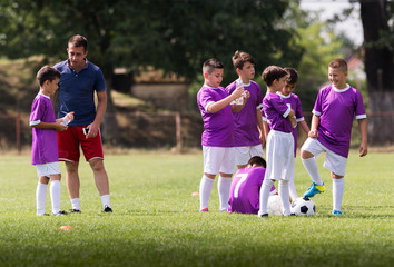 Coach is giving advice to soccer players on football match