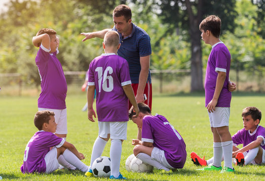Coach is giving advice to soccer players on football match