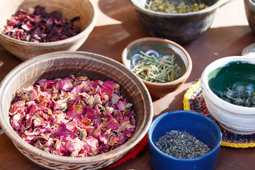 Different types of dry herbal tea leaves on table. Dried herbs, flowers, fruits, spices in ceramic plates stand on the table. Background. Selective focus