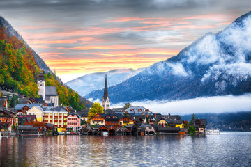 Scenic view of famous Hallstatt mountain village with Hallstatter lake. Foggy autumn sunrise on Hallstatt lake