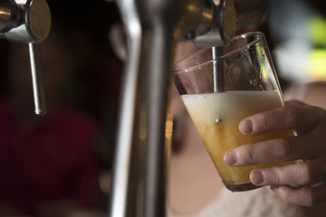 barmaid behind a beer tap