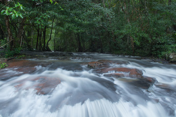 Fototapeta premium waterfalls in deep forest at National Park ,A beautiful stream water famous rain forest waterfall in Thailand