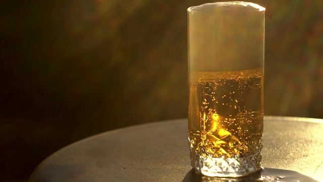 a glass of beer at sunset
