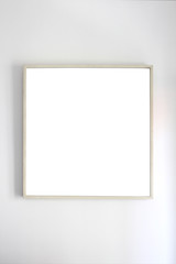 empty frame hange on a white wall with clipping path included and copy space