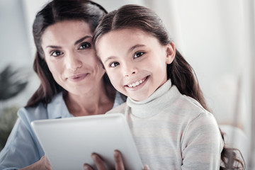 Modern family. Cheerful girl expressing positivity while sitting near her mother