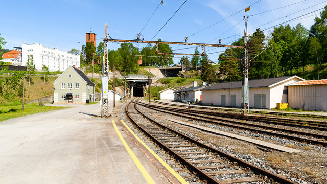Railway station with tracks leading into a dark tunnel. Location Notodden in Norway.