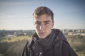portrait of a young man with a panorama of houses in background