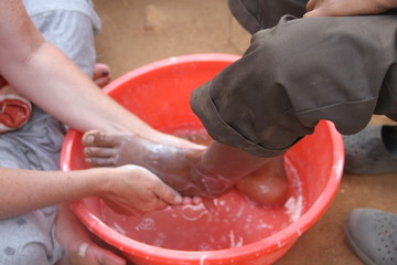 Volunteer washing a child's foot