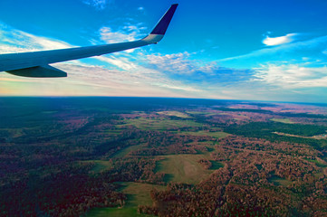 Clouds and skyline horizon panoramic view. Beautiful landscape of forests and fields with a bird's-eye view. View From Airplane.