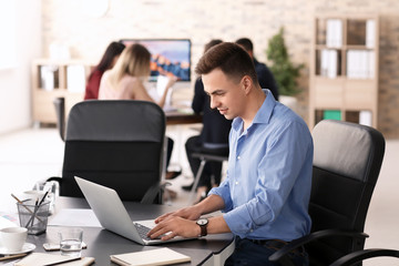 Naklejka premium Young man using laptop to get ready for business meeting in office