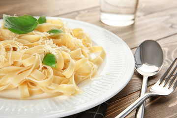 Plate of delicious pasta with cheese on table, closeup