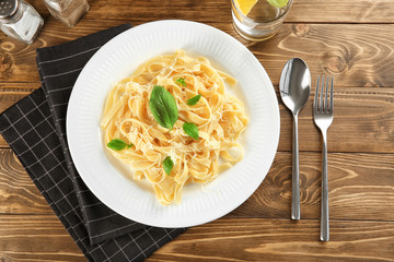 Plate of delicious pasta with cheese on table, top view