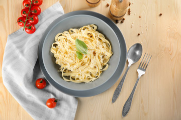 Plate of delicious pasta with cheese on table, top view
