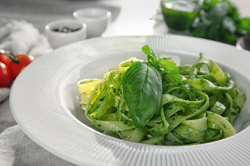 Plate of delicious pasta with pesto sauce on table, closeup