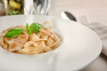 Plate of delicious pasta with chicken fillet, closeup