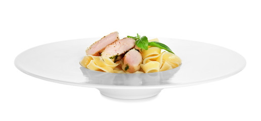 Plate of delicious pasta with chicken fillet on white background