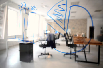 Office interior with tables and armchairs, view through glass board. Workplace design