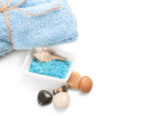 Sea salt with towel for spa procedures on white background