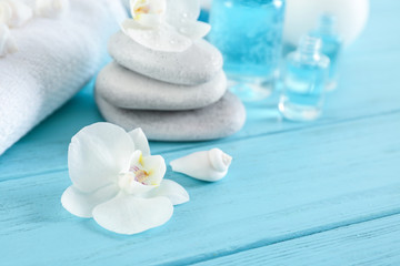 Beautiful flower with spa stones on wooden table