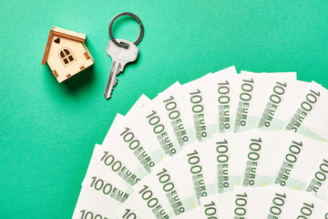 Toy house, key and euro banknotes
