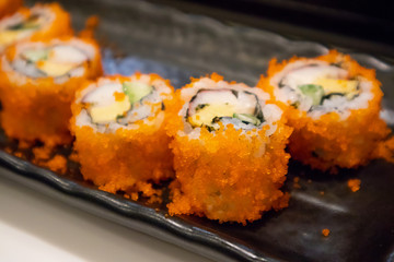 California maki sushi roll on black plate, japanese food