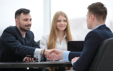 handshake financial partners sitting at the table