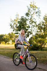 Fototapeta na wymiar young woman in a hat with a bike in the park. Active people. Outdoors