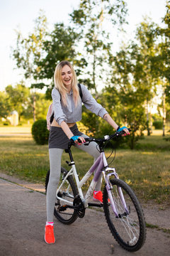 young woman in a hat with a bike in the park. Active people. Outdoors