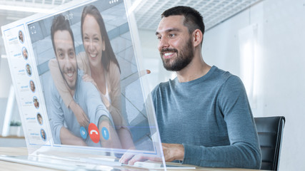 In the Near Future Man Makes Video Call from Computer with Transparent Display to His Friend. They Have Friendly Chat. Office Design is Modern and Bright.
