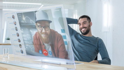 In the Near Future Man Makes Video Call from Computer with Transparent Display to His Friend. They Have Friendly Chat. Office Design is Modern and Bright.
