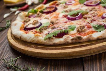 Minced meat tomato red onion pizza on a wood background