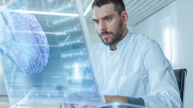 In the Futuristic Laboratory Male Scientist Works on His Transparent Computer Display with Graphic Projection of Neural Network in Brain, Artificial Intelligence Simulation.